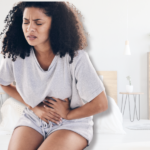 A woman is dealing with heavy periods and anemia and is leaning over because she is cramping